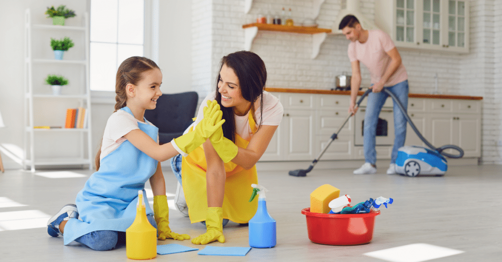 a girl and woman high fiving while cleaning the floor